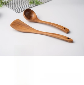 Detail of teak wood spatula and soup spoon with natural grain and hanging holes