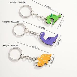 Three cute wooden dinosaur keychains in green, purple, and yellow with size measurements