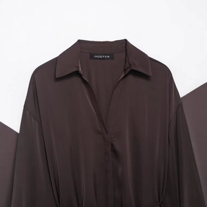 Elegant dark brown satin silk shirt dress with belt on minimalist geometric background