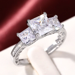 Makroaufnahme eines Drei-Stein-Rings im Prinzess-Schliff mit klassischer Vier-Krallen-Fassung