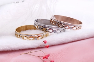 Detailed view of infinity steel bracelets in gold, silver, and rose gold with double row crystals