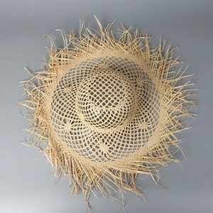 Detail of wide brim straw sun hat featuring unique frayed edges and woven texture