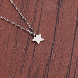 Macro shot of silver stainless steel star pendant necklace on brown textured background