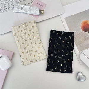 Détail de pochettes de téléphone en mousseline fleurie noire et beige avec fermoirs à pression
