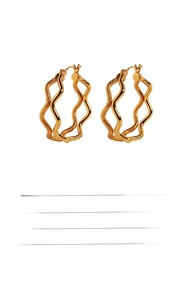 Detail showing the 3.1cm diameter golden brass wave earrings with polished finish