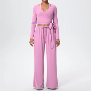 Ensemble de yoga rose avec haut court croisé à manches longues et pantalon large taille haute