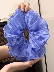 Detailed view of the large purple pleated fabric scrunchie with fine accordion folds