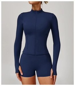 Detail view of the navy blue yoga jacket featuring thumbholes and invisible zipper