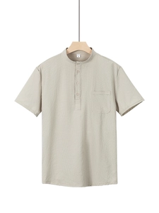 Close-up of beige seersucker shirt featuring a Henley collar and buttoned chest pocket