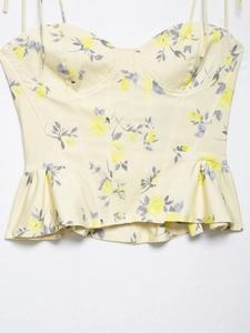 Detail of floral poplin camisole top showing yellow flower pattern and ruffled hemline