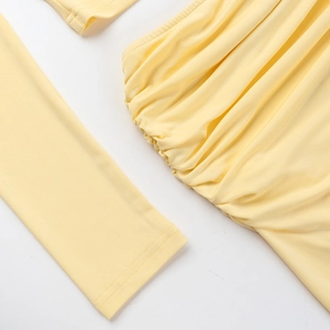Close-up detail of the yellow long sleeve dress showing elegant ruching and knit texture
