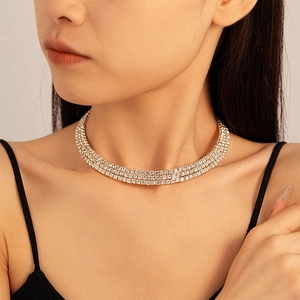 Detail showing a triple-layer diamond choker necklace with sparkling crystals on a model