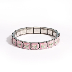 Detailed macro view of silver stainless steel Italian charm bracelet with pink daisy pattern
