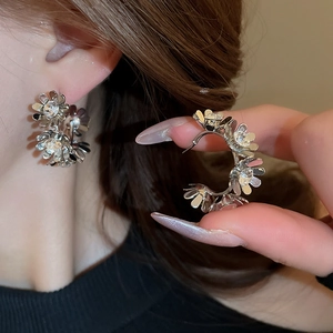 Vintage floral C-shape stud earrings in silver metal with sparkling crystal centers