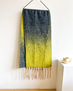 Detail of soft thick scarf with yellow and dark blue gradient and decorative fringes