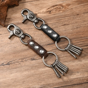 Vintage leather skull keychain in black and brown on a rustic wooden background