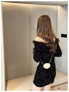 Close-up of a chic light beige mini chain bag paired with a black sequin feather dress