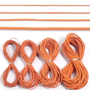 Detail showing four different diameters of orange genuine leather cords for DIY crafts