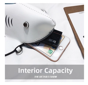 Internal capacity of mini shark crossbody bag showing space for phone and makeup
