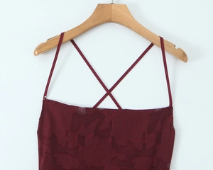 Makro-Detail von weinrotem Jacquard-Muster und dünnen Trägern am rückenfreien Kleid
