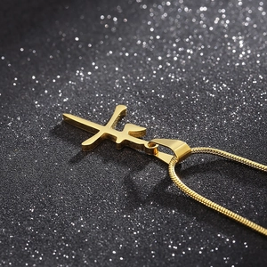 Detailed close-up of golden Chinese 'Niu' character pendant on a sleek snake chain