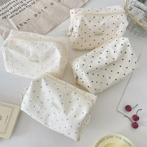 Flat lay of striped heart makeup bags in four colors with high-quality woven fabric texture