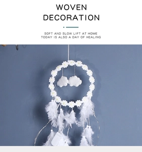 Macro detail of white dream catcher featuring daisy accents and cloud feather pendants
