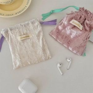 Detail of velvet drawstring pouches with lace trim for storing earphones and makeup