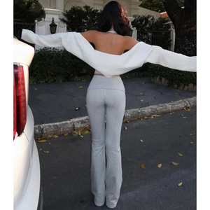 Vista posteriore del set 3 pezzi con scialle in maglia bianca e pantaloni grigi a zampa