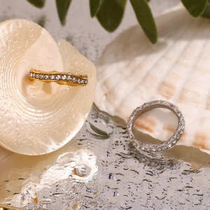 Detail of 18K gold and silver wavy eternity rings with inlaid sparkling zircons