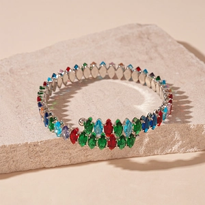Détail du collier avec zircons multicolores en forme de goutte sur texture en pierre