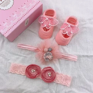 Close-up of baby girl pink lace headband and socks set with pearls and roses