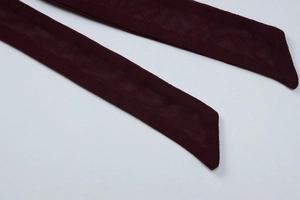 Gros plan des bretelles en maille bordeaux avec texture détaillée et coupe en biais