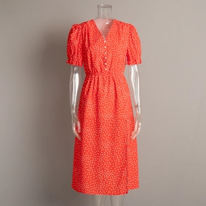 Detail of V-neckline with white buttons and puff sleeves on red polka dot midi dress