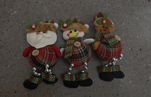 Detailed view of Christmas plush ornaments featuring Santa, snowman, and reindeer figures