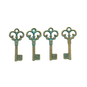 Detailed view of four vintage bronze key pendants with antique finish for DIY jewelry