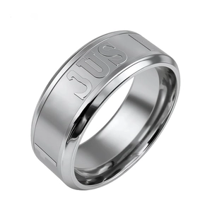 Close-up of silver titanium steel ring featuring engraved JUST lettering on a wide band