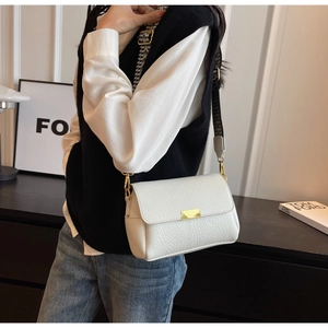 Detail of white lychee pattern crossbody bag with gold buckle and wide strap
