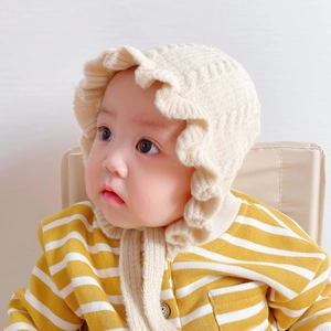 Infant winter knit hat with lace trim and yellow striped cardigan on a baby model