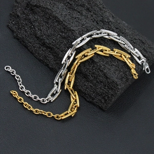 Macro shot of gold and silver rectangle chain bracelets on black stone background