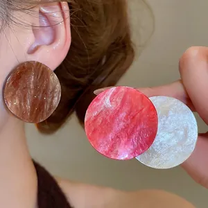 Minimalist geometric acrylic round earrings with marble texture on female model
