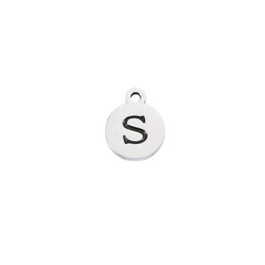 Macro shot of mirror-polished stainless steel round pendant with engraved letter S
