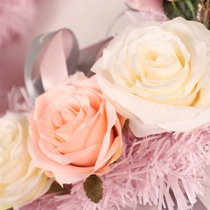 Artificial pink and cream rose wreath with decorative feathers and silk ribbon for decor