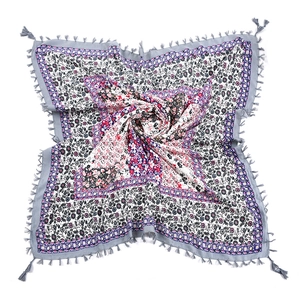 Detail of square bohemian scarf featuring floral patterns and gray fringe tassels