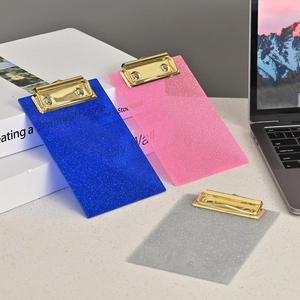 Three glitter acrylic clipboards in blue, pink, and silver with gold metal clips