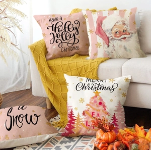 Pink Christmas pillow covers set with festive motifs on a cozy sofa with yellow blanket