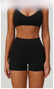 Detail view of high waist yoga shorts and V-neck sports top in premium black