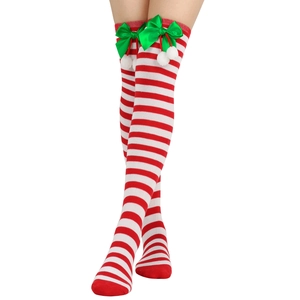 Detail of red and white striped Christmas over-knee socks with green bow and white pompom