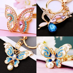 Detailed close-up of butterfly keychains with colorful rhinestones and faux pearls