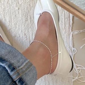 Detailed close-up of minimalist S925 sterling silver anklet with olive beads on ankle